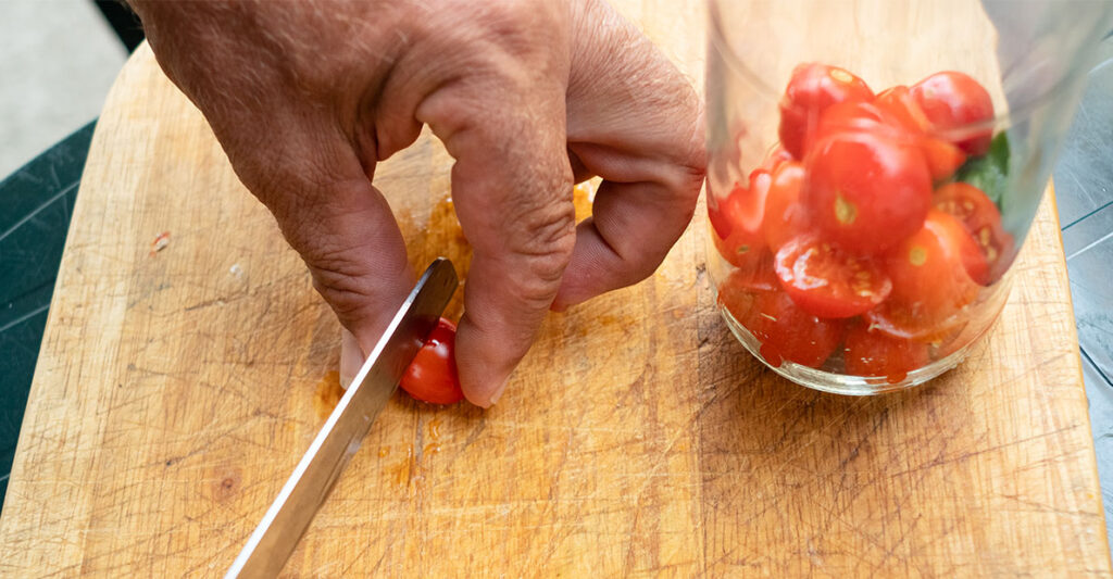 3A_Cut Tomatoes in Half Hand cutting tomatoes in half